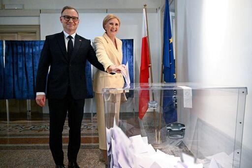 Andrzej Duda i Agata Konrhauser-Duda wrzucają głosy do urny.