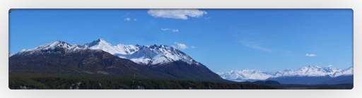 framed photo landscape Panorama. 
dark green trees moving up to a white snowcapped mountain. above that, a sky fading from light to dark blue. 